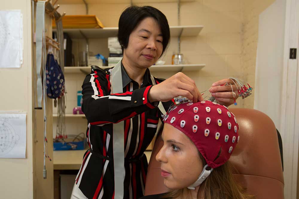 研究人员与患者一起准备EEG设备