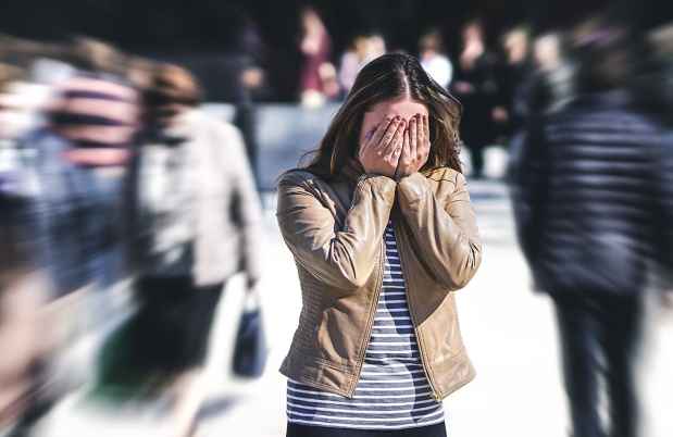 年轻女子在失焦人群中遮住眼睛